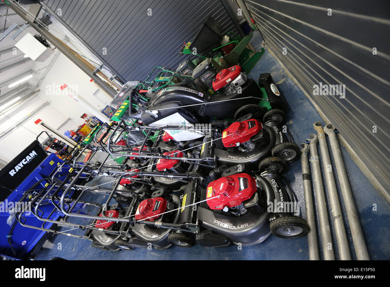 A collection of lawn mowers locked away in a grounds maintenance building Stock Photo