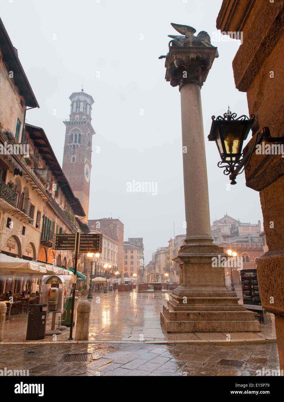 VERONA, ITALY - JANUARY 28, 2013: Piazza Erbe in rainly dusk and Lamberti tower Stock Photo