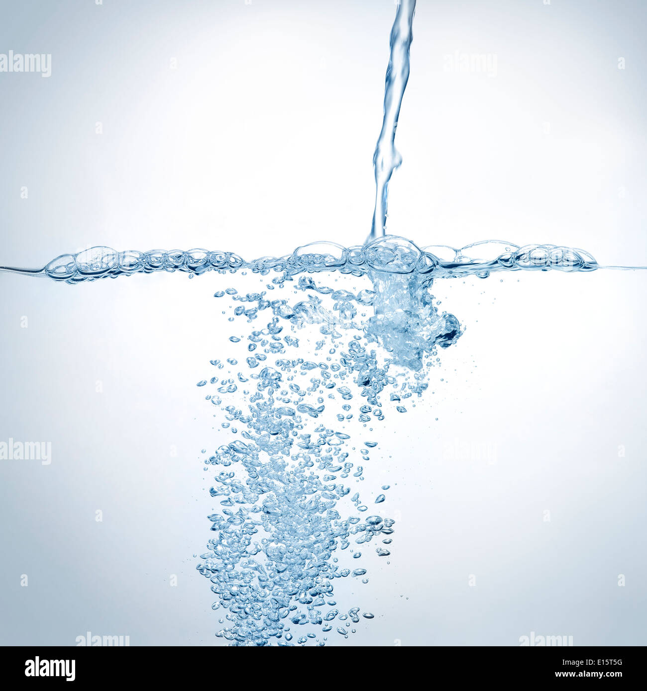 Water jet splashing and bubbles in blue tone Stock Photo
