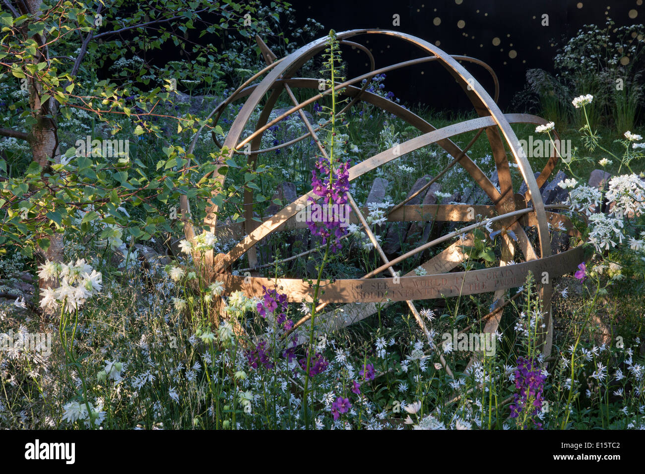 English cottage garden with copper sun dial sundial and flower border borders bed beds flowering in spring summer UK Stock Photo