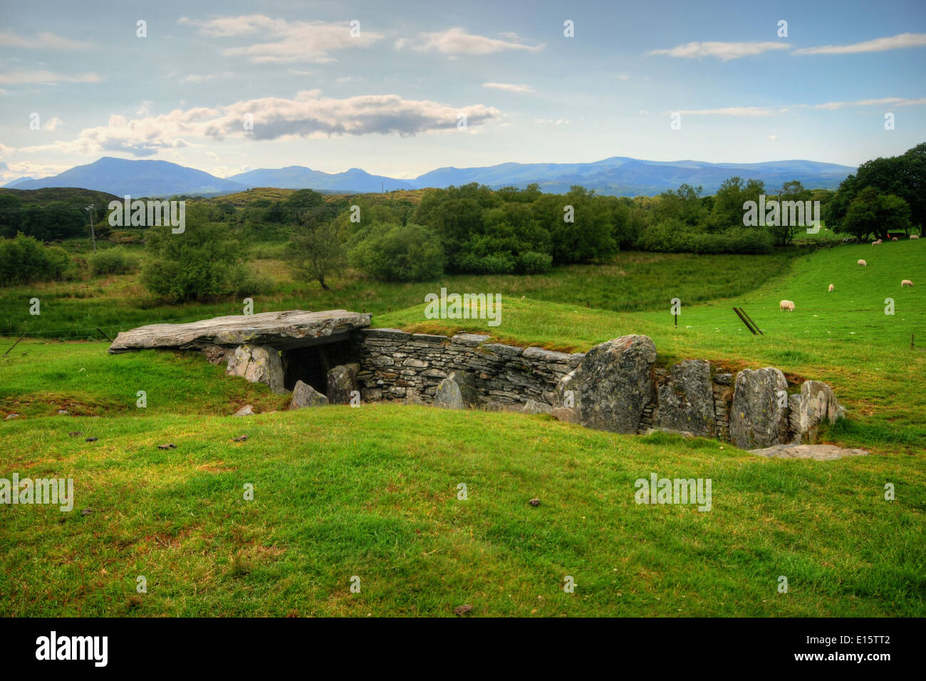 Prehistoric burial chamber in Capel Garmon, North Wales, with the Snowdonia mountain range behind Stock Photo