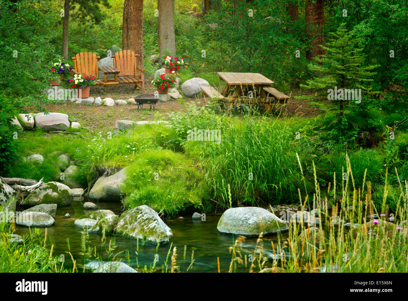Picnic site with table chairs and flowers along Gore Creek. Vail, Colorado Stock Photo