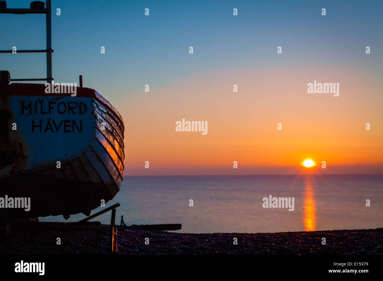 Sunrise with boat on Aldeburgh beach Stock Photo