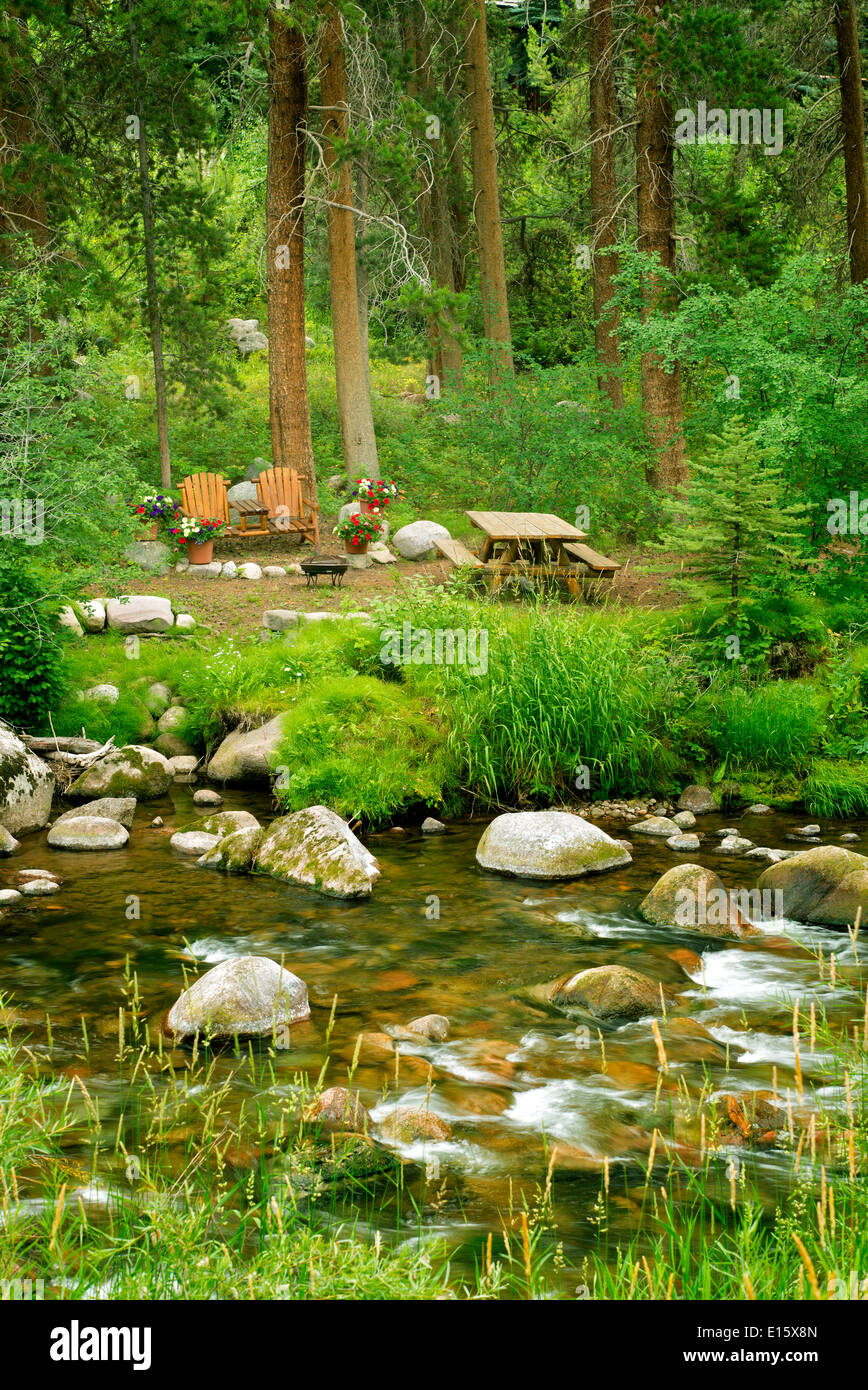 Picnic site with table chairs and flowers along Gore Creek. Vail, Colorado Stock Photo