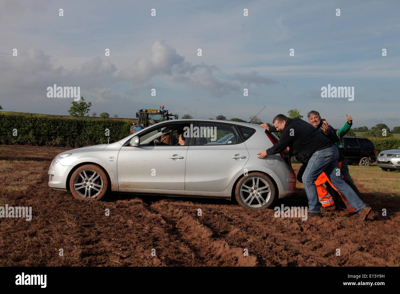 Exeter, Devon, UK. 23rd May, 2014. Devon County Show cancelled because of safety concerns due to heavy rain. The rain left car parks unusable. Tractors help get cars out of the deep mud. Credit:  Anthony Collins/Alamy Live News Stock Photo