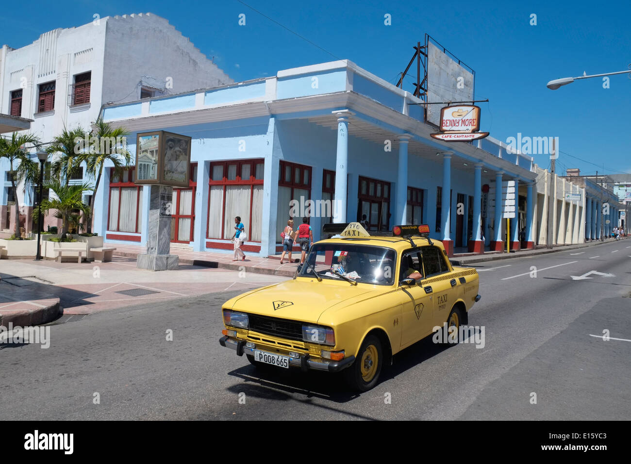 A yellow taxi passing Café Cantante Benny Moré, Cienfuegos, Cuba. Stock Photo
