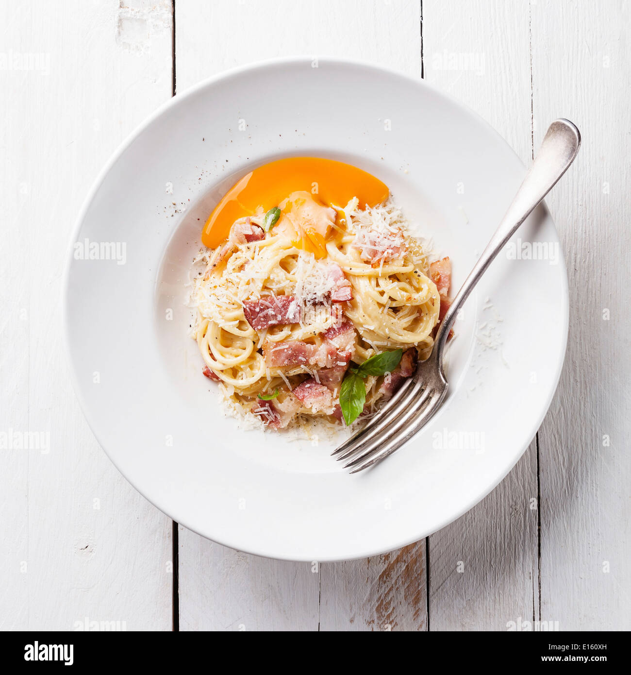 Pasta Carbonara on white plate with parmesan and yolk Stock Photo