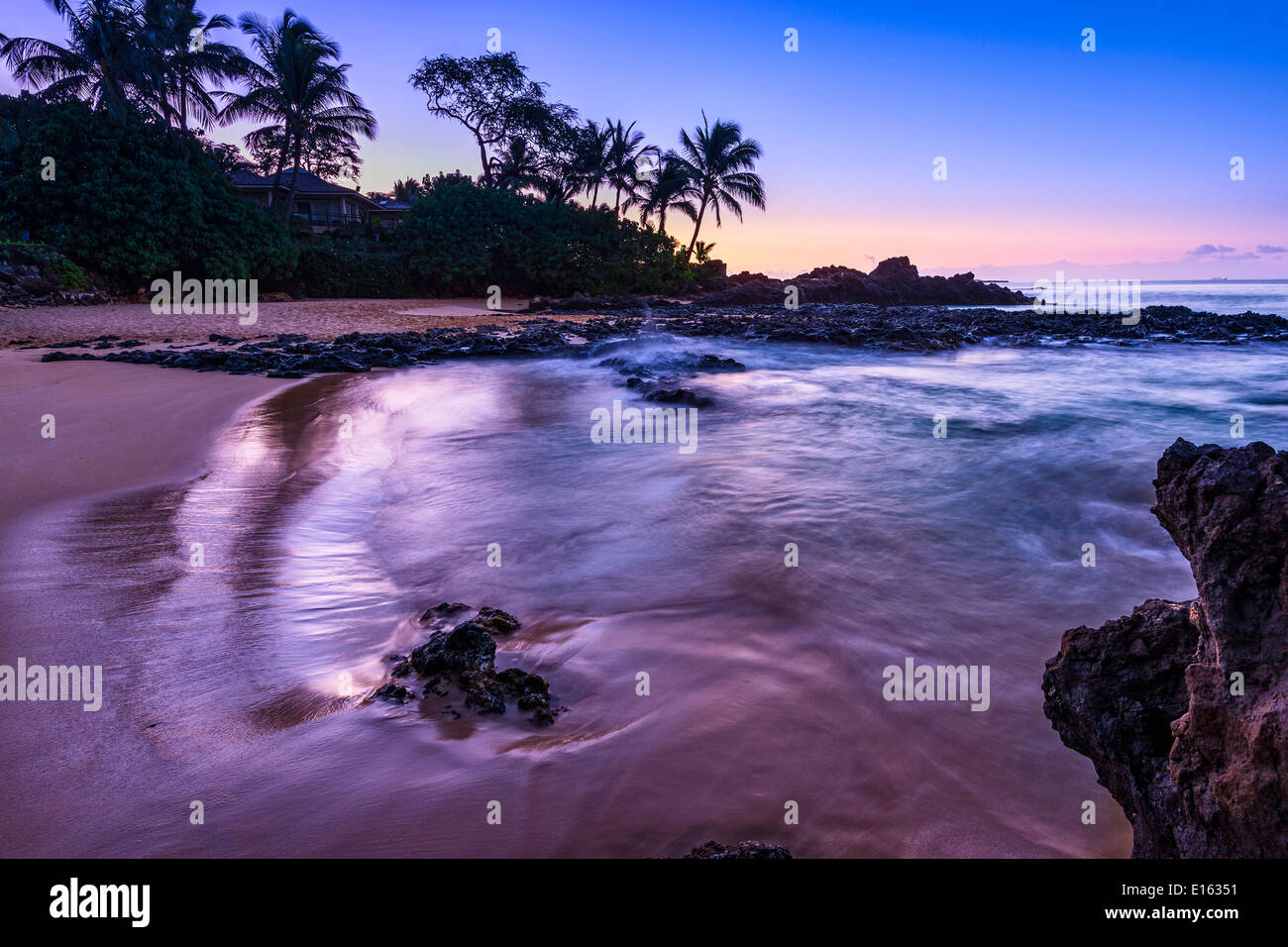 The Moon glowing over Secret Beach in Maui. Stock Photo