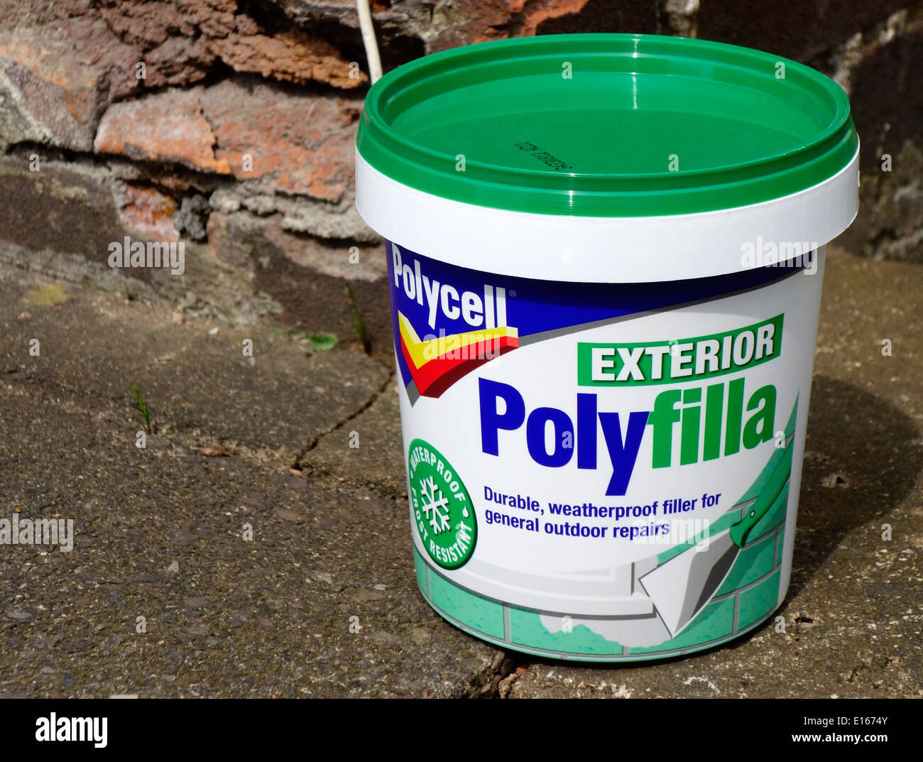 Tub of Polycell Exterior Polyfilla with Frost Damaged Brickwork Behind