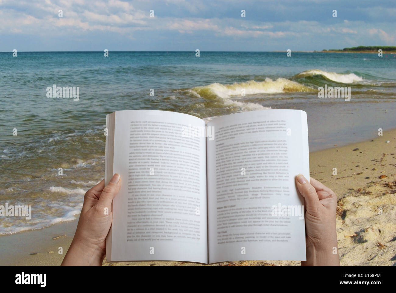 woman reading a book on the beach Stock Photo