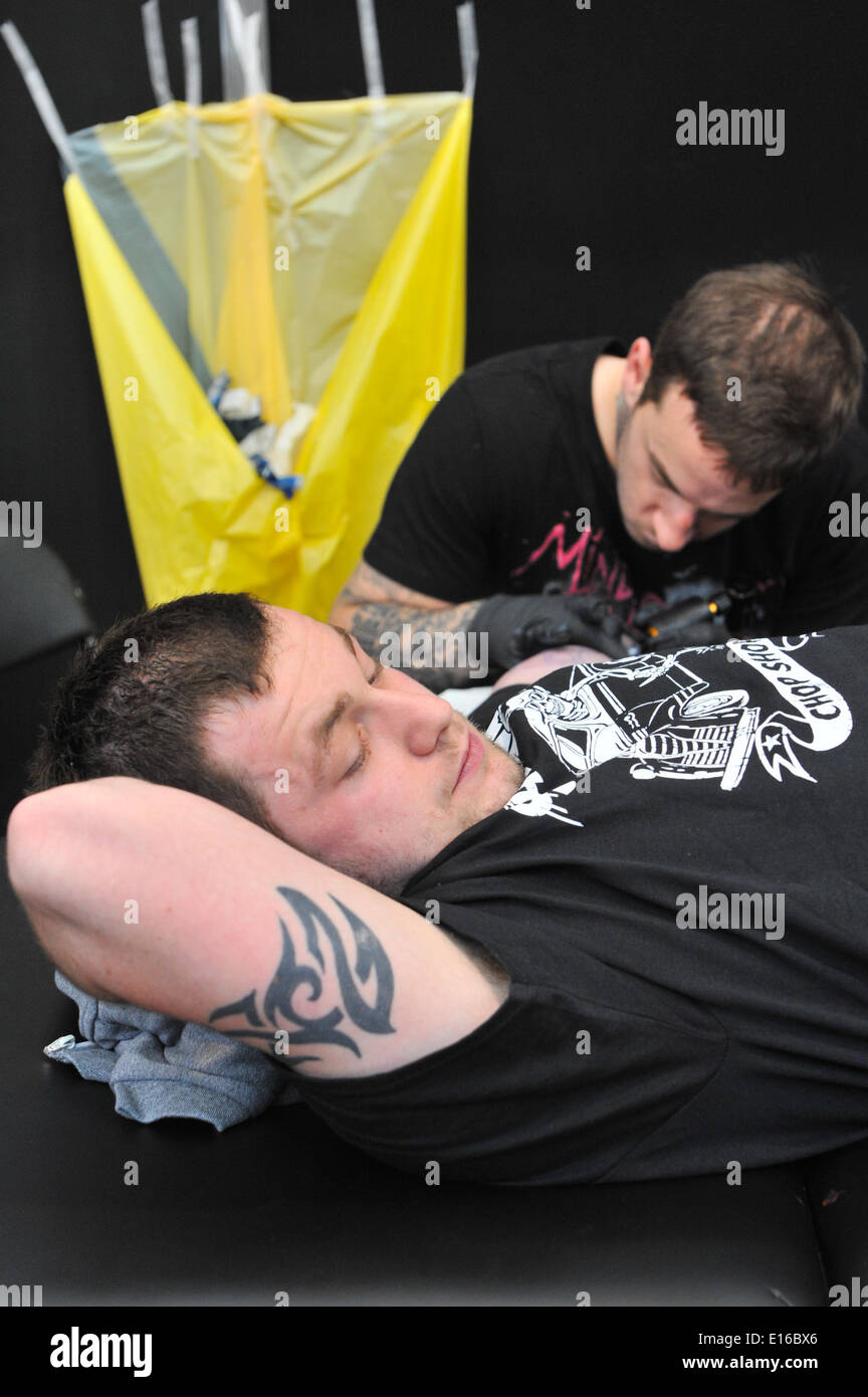 Alexandra Palace, London, UK. 24th May 2014. A tattoo artist at work at the Great British Tattoo Show taking place this weekend at Alexandra Palace. The show features tattooing,  stall selling clothing and accessories, wrestling and a fashion show Credit:  Matthew Chattle/Alamy Live News Stock Photo