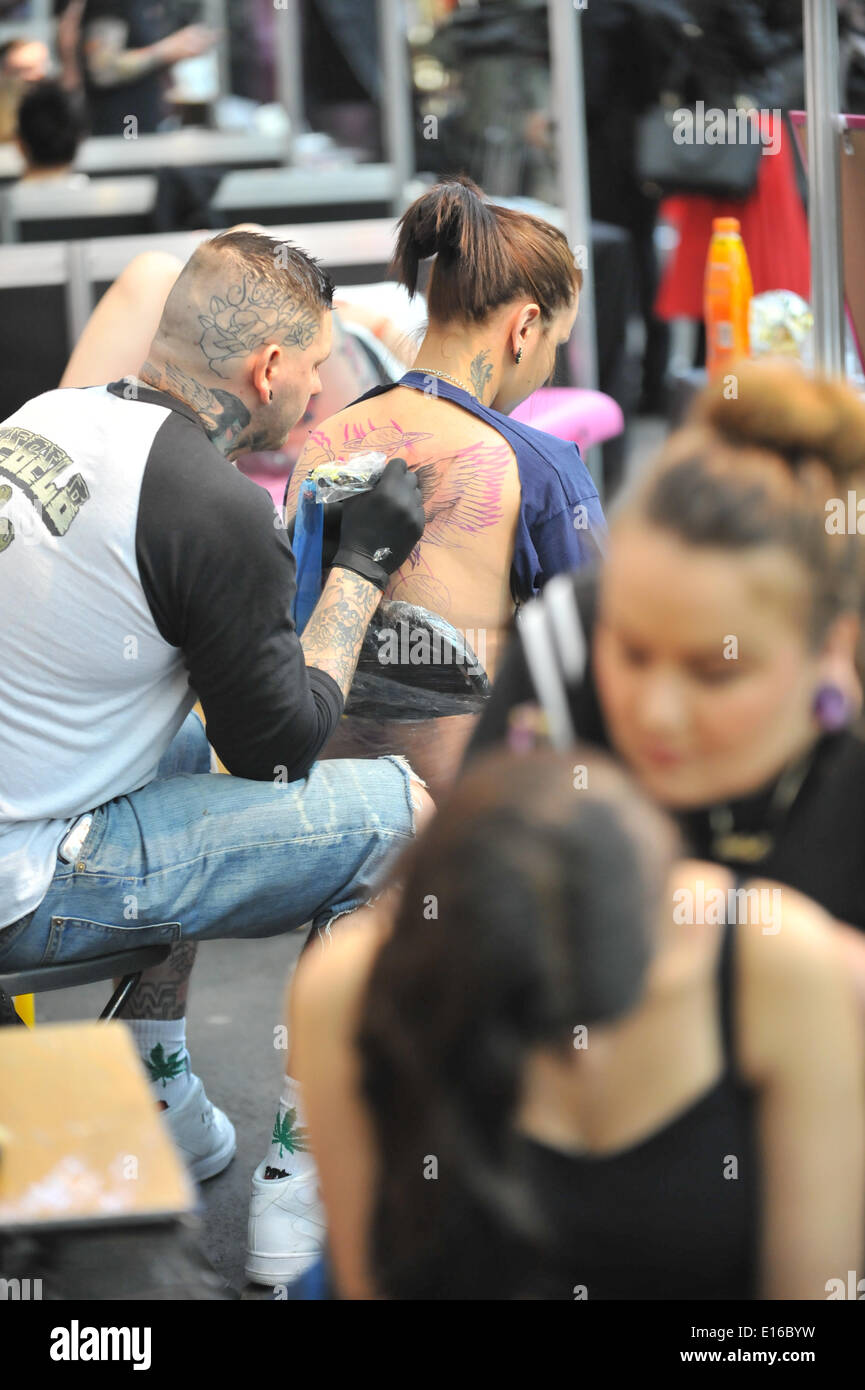 Alexandra Palace, London, UK. 24th May 2014. Tattooing a womans back at the Great British Tattoo Show taking place this weekend at Alexandra Palace. The show features tattooing,  stall selling clothing and accessories, wrestling and a fashion show Credit:  Matthew Chattle/Alamy Live News Stock Photo