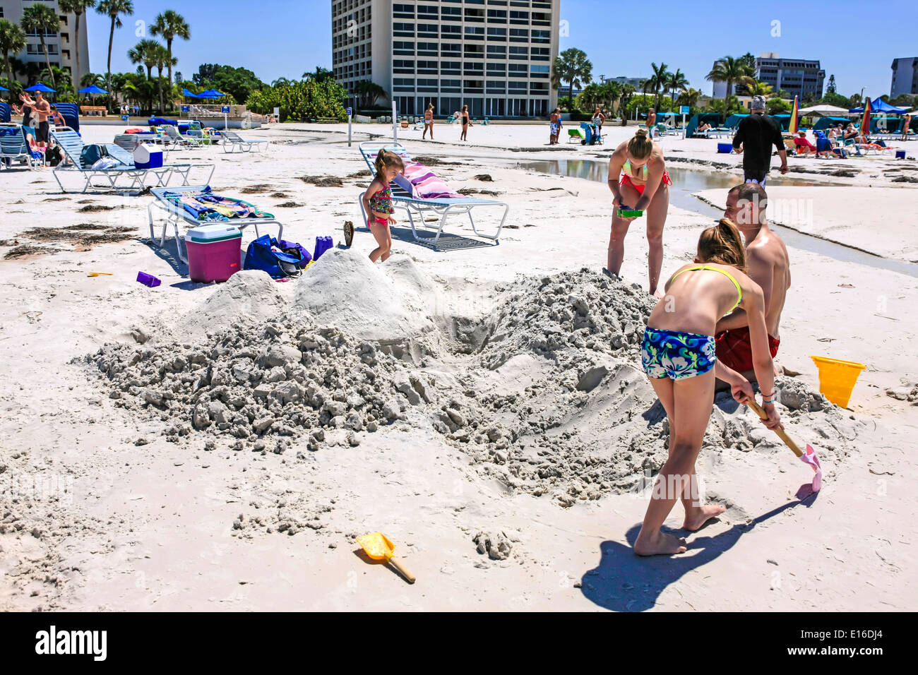 Family group work as a team to build a sandcastle on Siesta Key beach in Florida Stock Photo