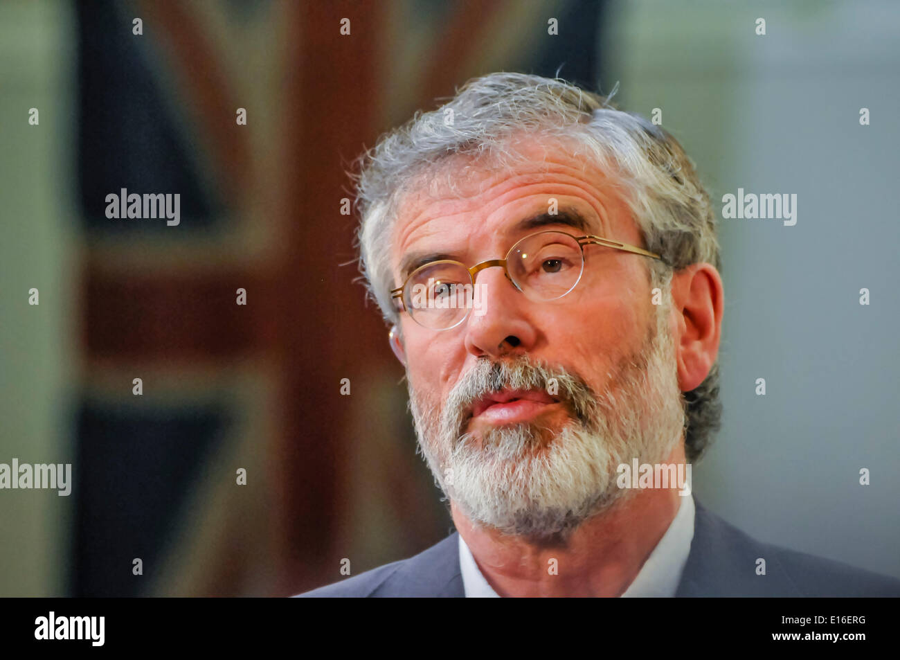 Belfast, Northern Ireland. 24 May 2014 - Sinn Fein President, Gerry Adams (TD for Louth), stands in front of a Union Flag inside Belfast City Hall while he is being interviewed during a live television broadcast Credit:  Stephen Barnes/Alamy Live News Stock Photo