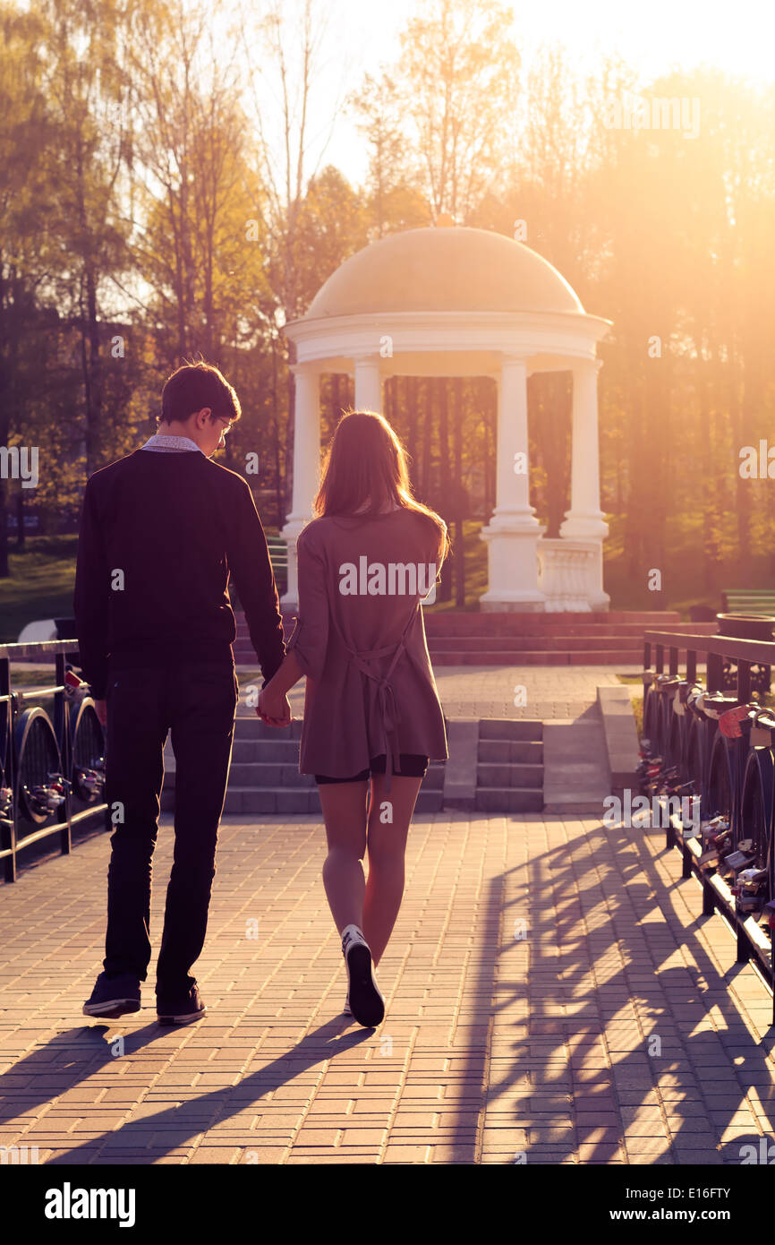 Young fashion elegant stylish couple posing in a European city park at dawn. Hipster cute girl with handsome man having fun outd Stock Photo