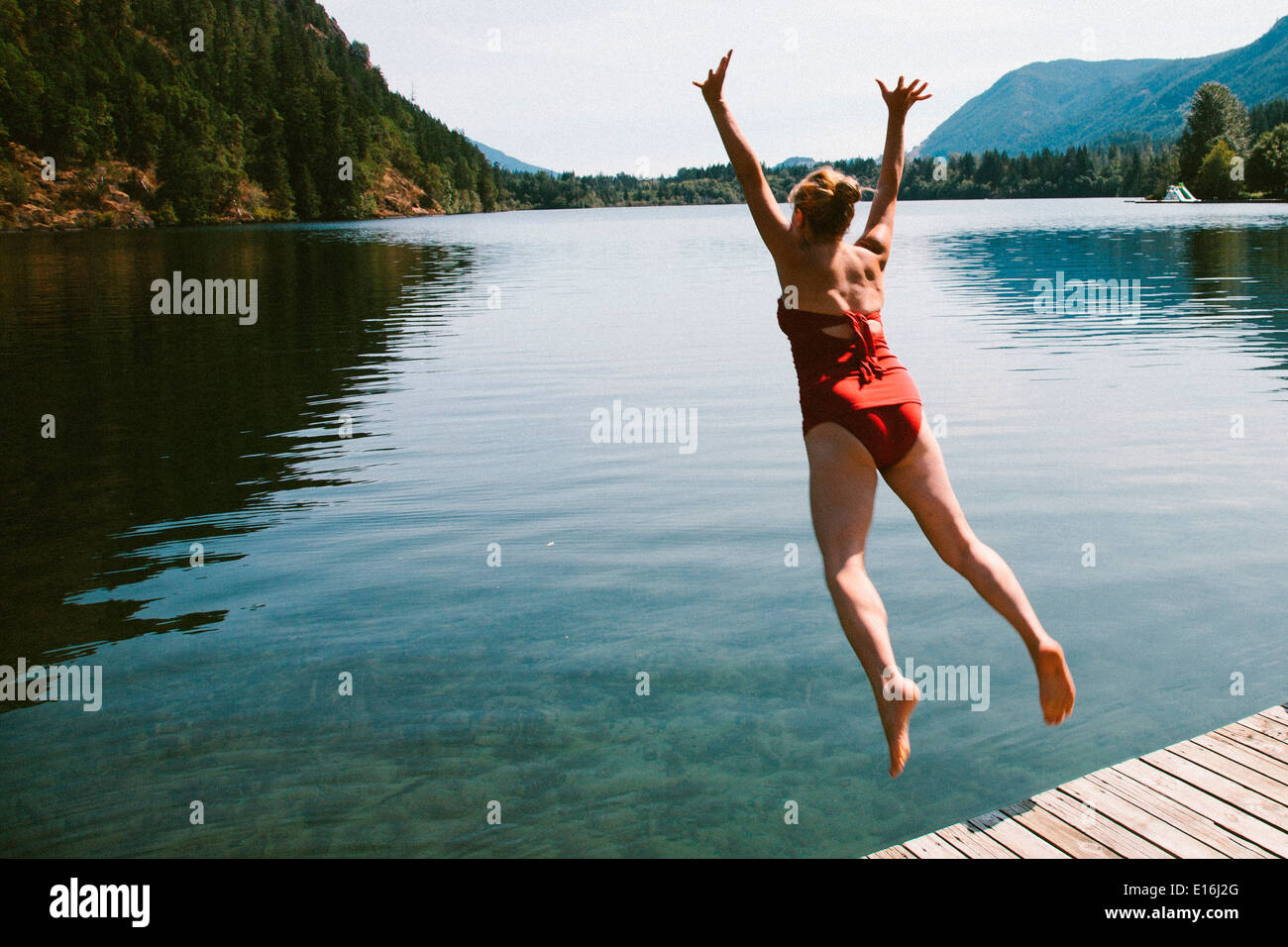 Woman jumping into water, Lake Cowichan, British Columbia, Canada Stock Photo