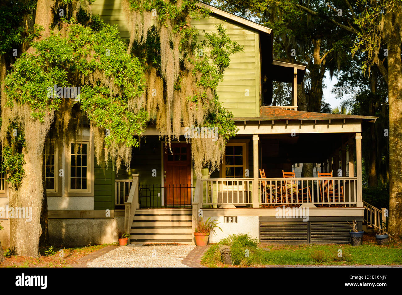 An historic house in Low country with rocking chairs on porch with Spanish moss hanging from trees in the yard, St. Mary's, GA Stock Photo