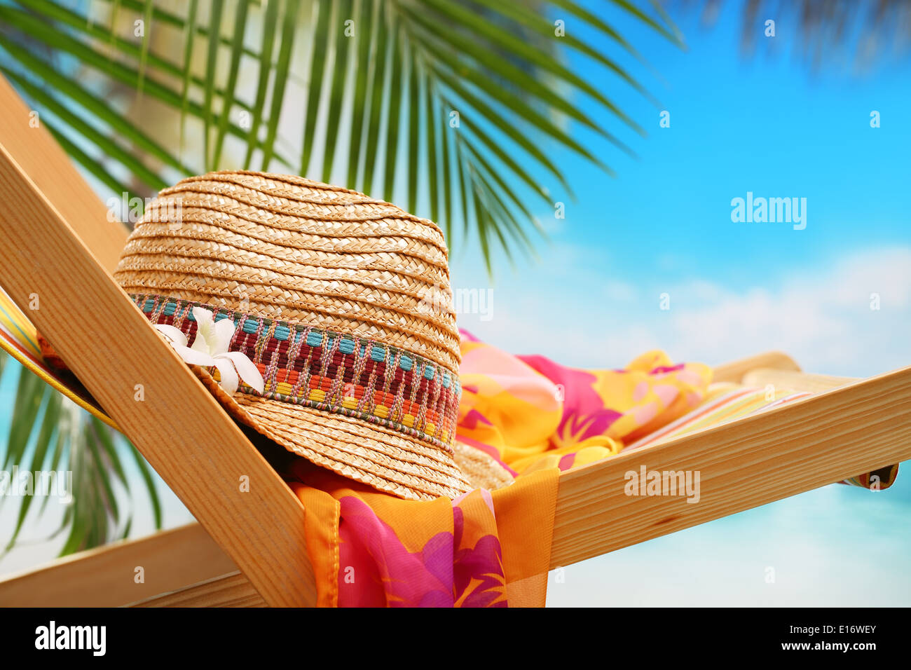 Summer holiday setting with straw hat on beach chair Stock Photo