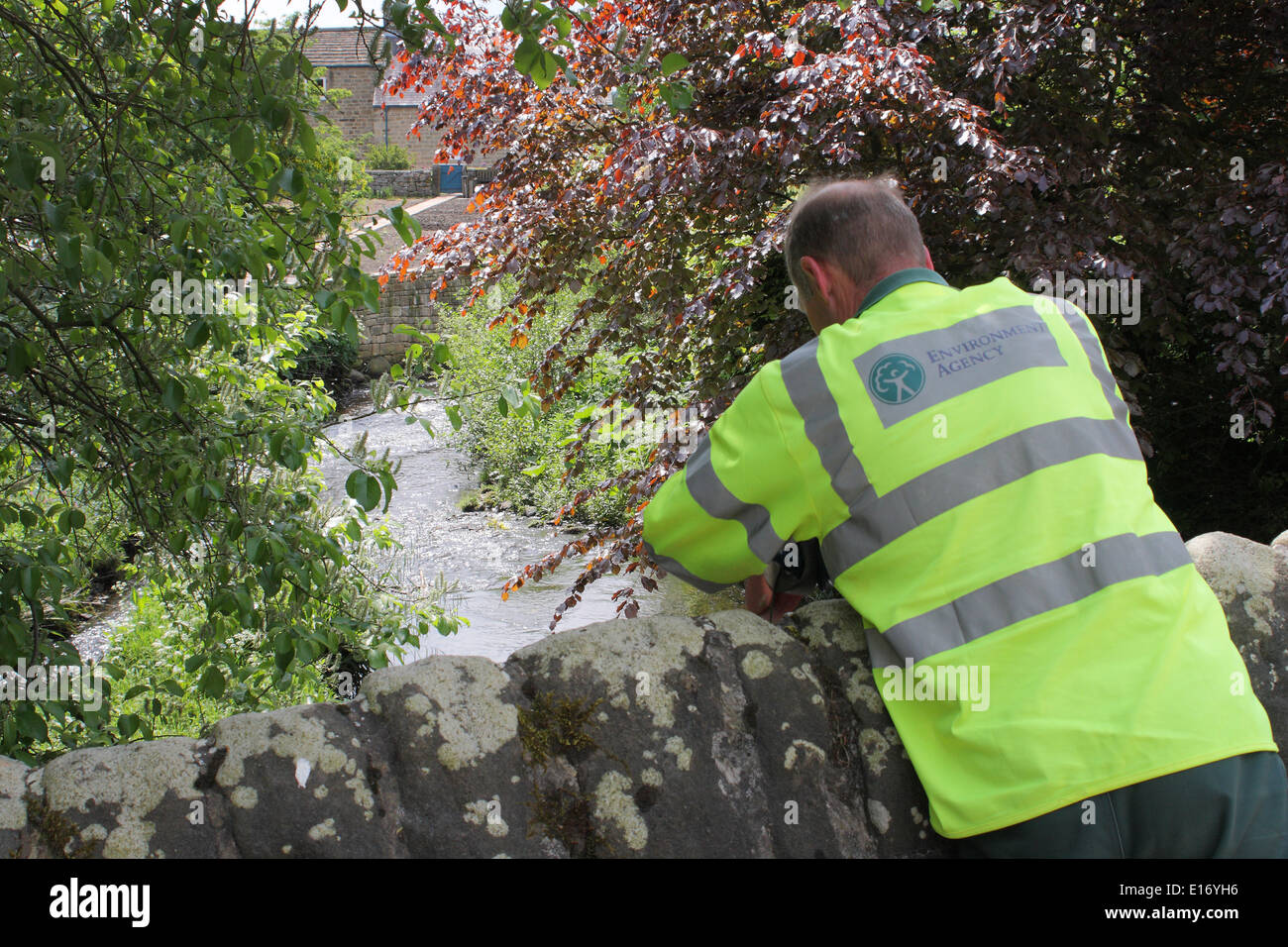 An Environment Agency worker takes a water sample from the River Derwent at Baslow, Peak District, Derbyshire, England, UK Stock Photo