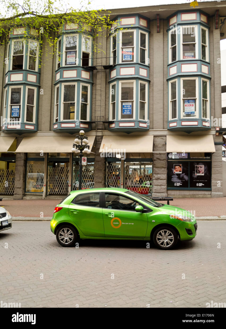 A 'modo car' car-sharing in Vancouver, Canada.  On the streets of historic Gastown Vancouver.  Heritage buildings and shops. Stock Photo