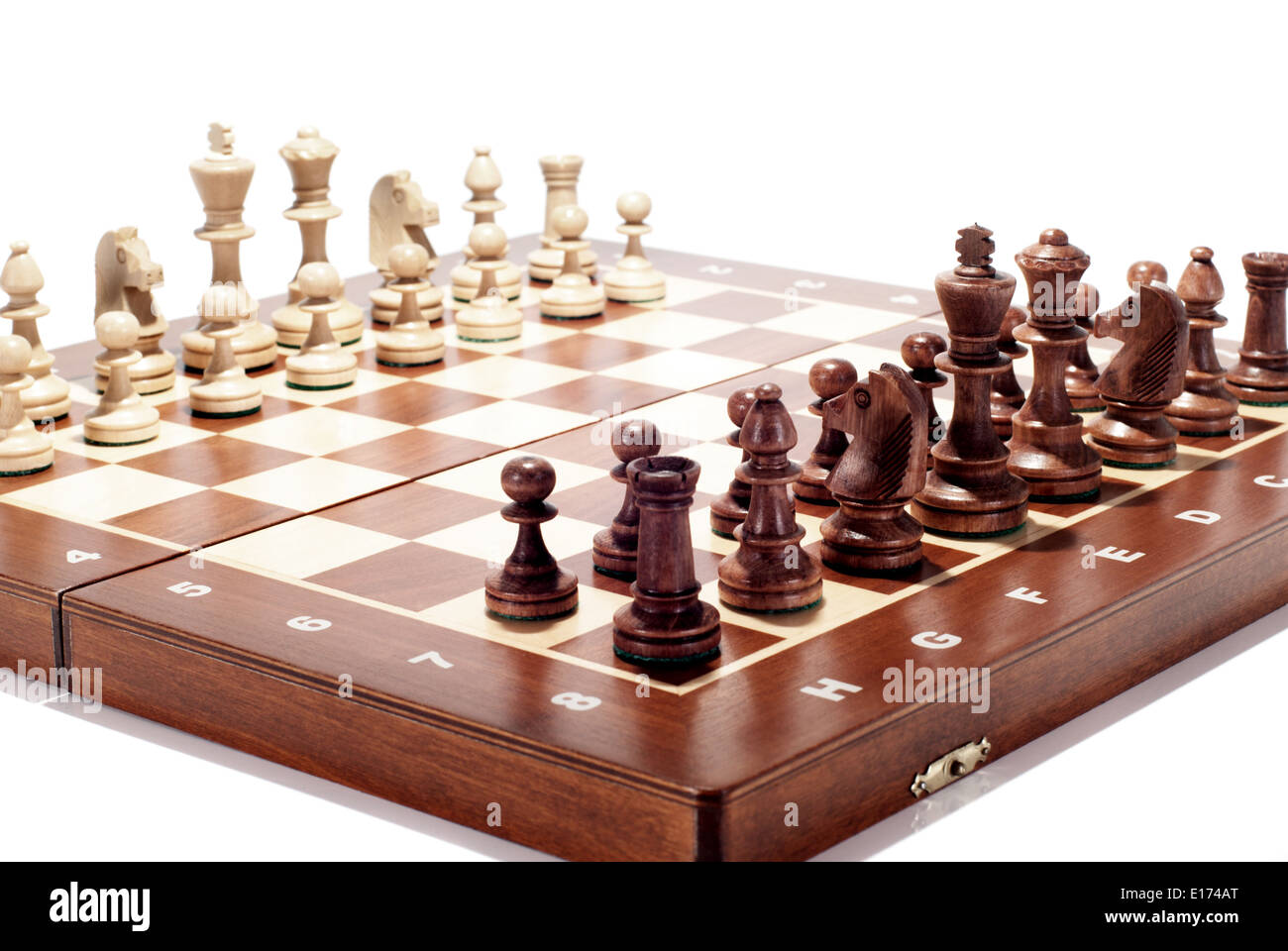 A wooden chess board isolated on white. The focus is on the front part of the board. Stock Photo
