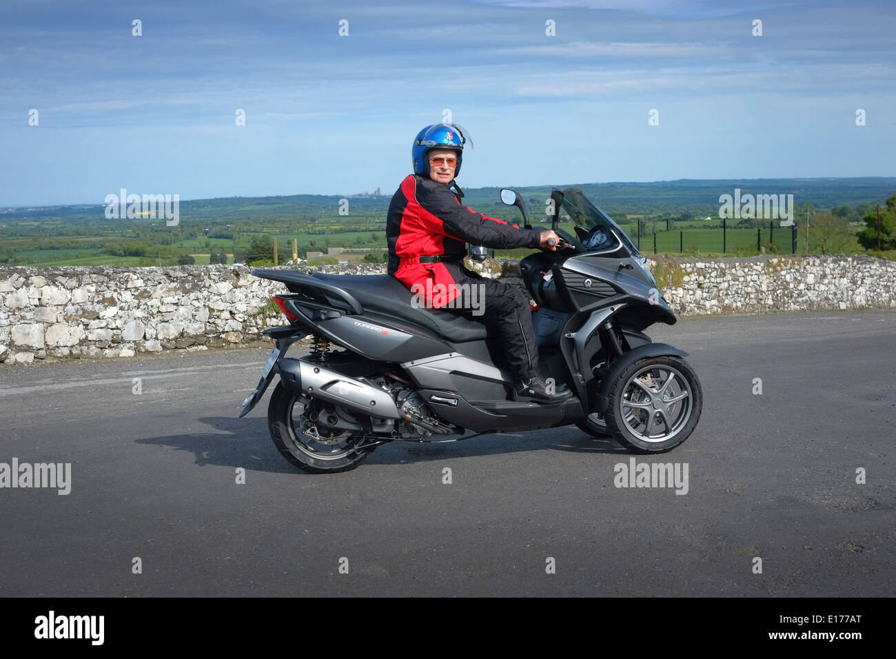 three wheeled Motor scooter, Man on a Quadro 350s tilting three wheeler motorcycle Stock Photo