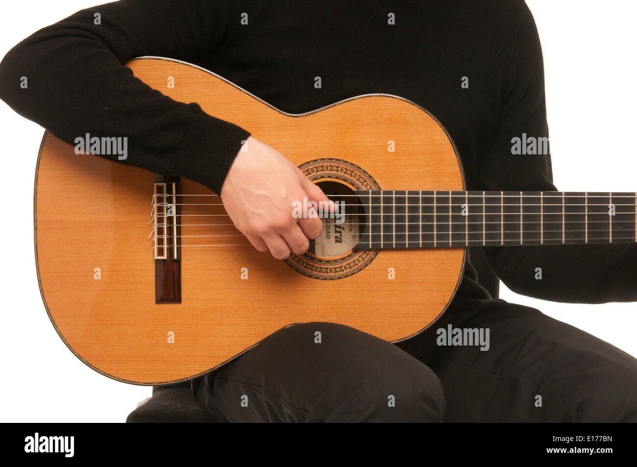 Close up of male guitarist demonstrating how to strum using a classical