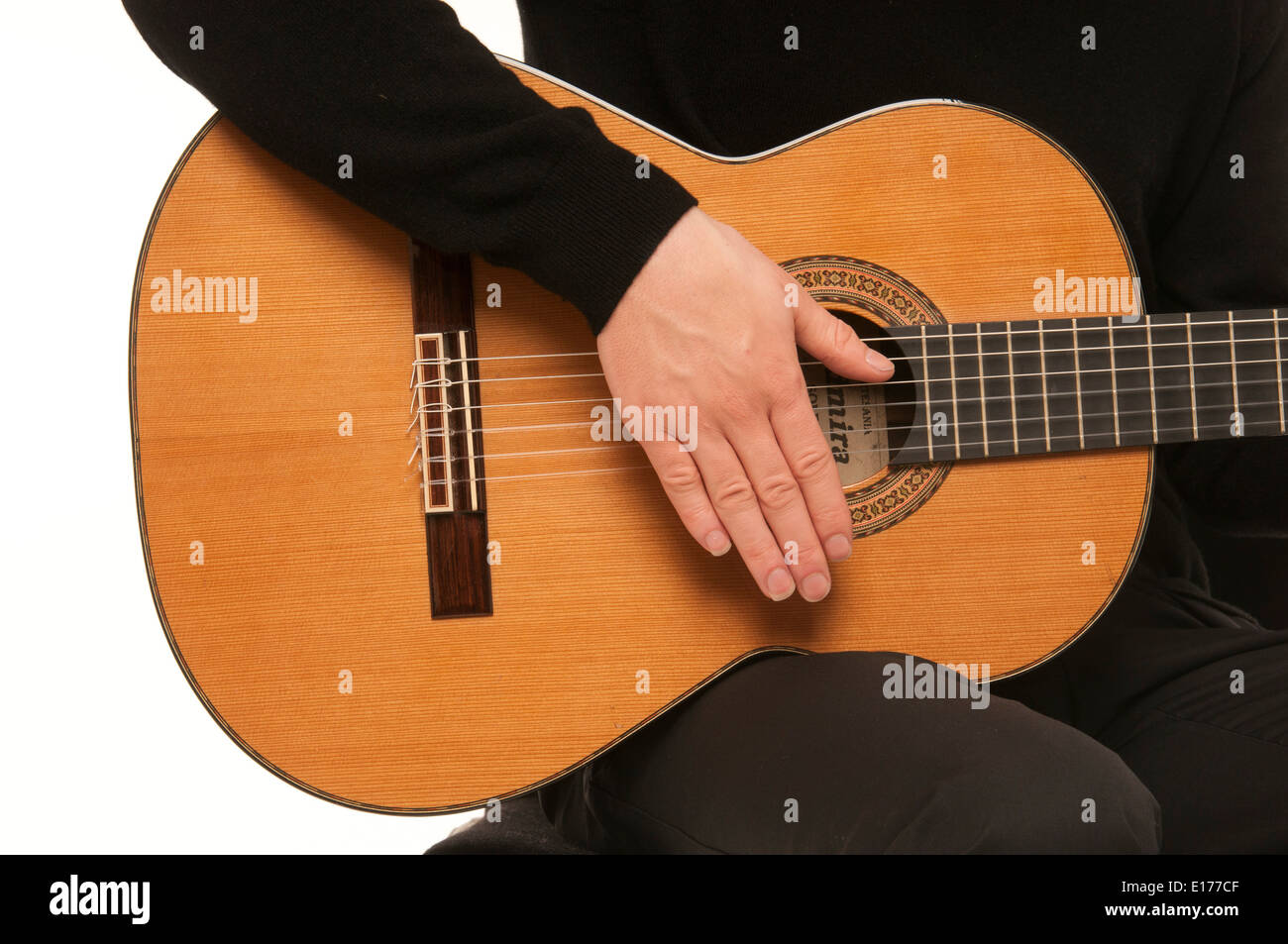 Close up of male guitarist demonstrating how to strum using a classical acoustic guitar Stock Photo