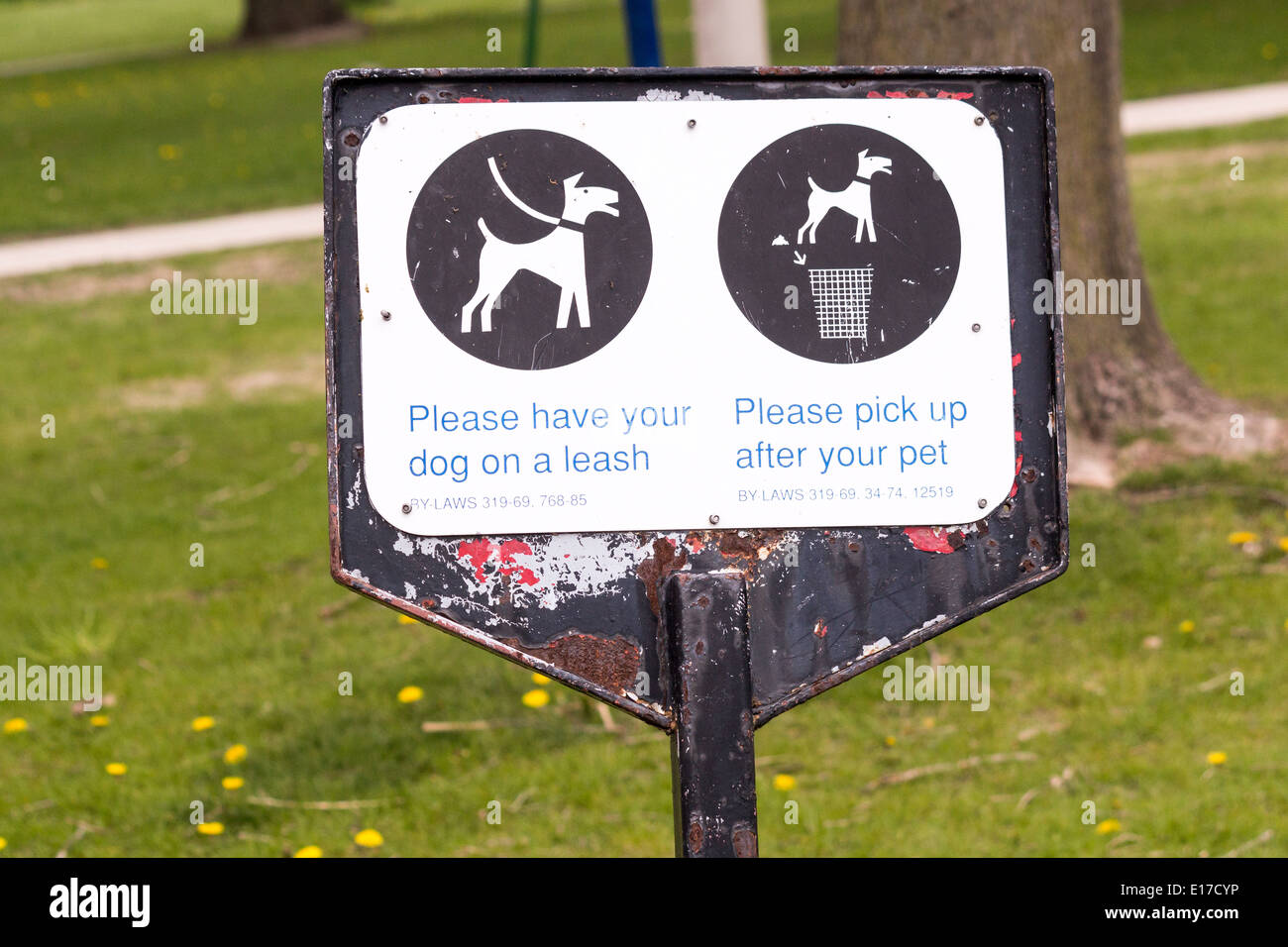 Sign for dog owners to keep dog on lease and to scoop and pick up after their dog. Stock Photo