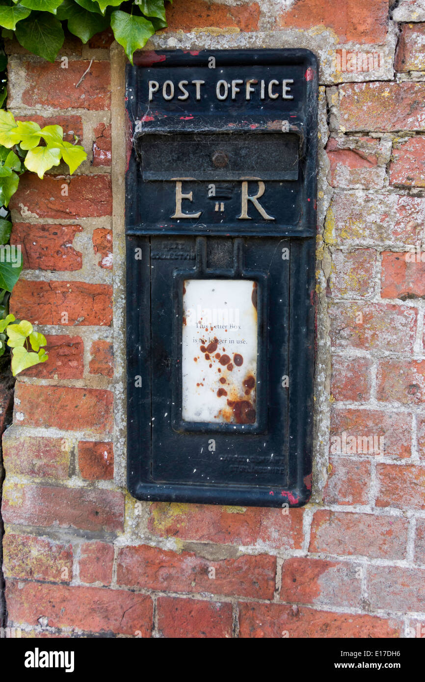 A disused post office letter box painted black sealed closed and with a notice 'This Letter Box is no longer in use' Stock Photo