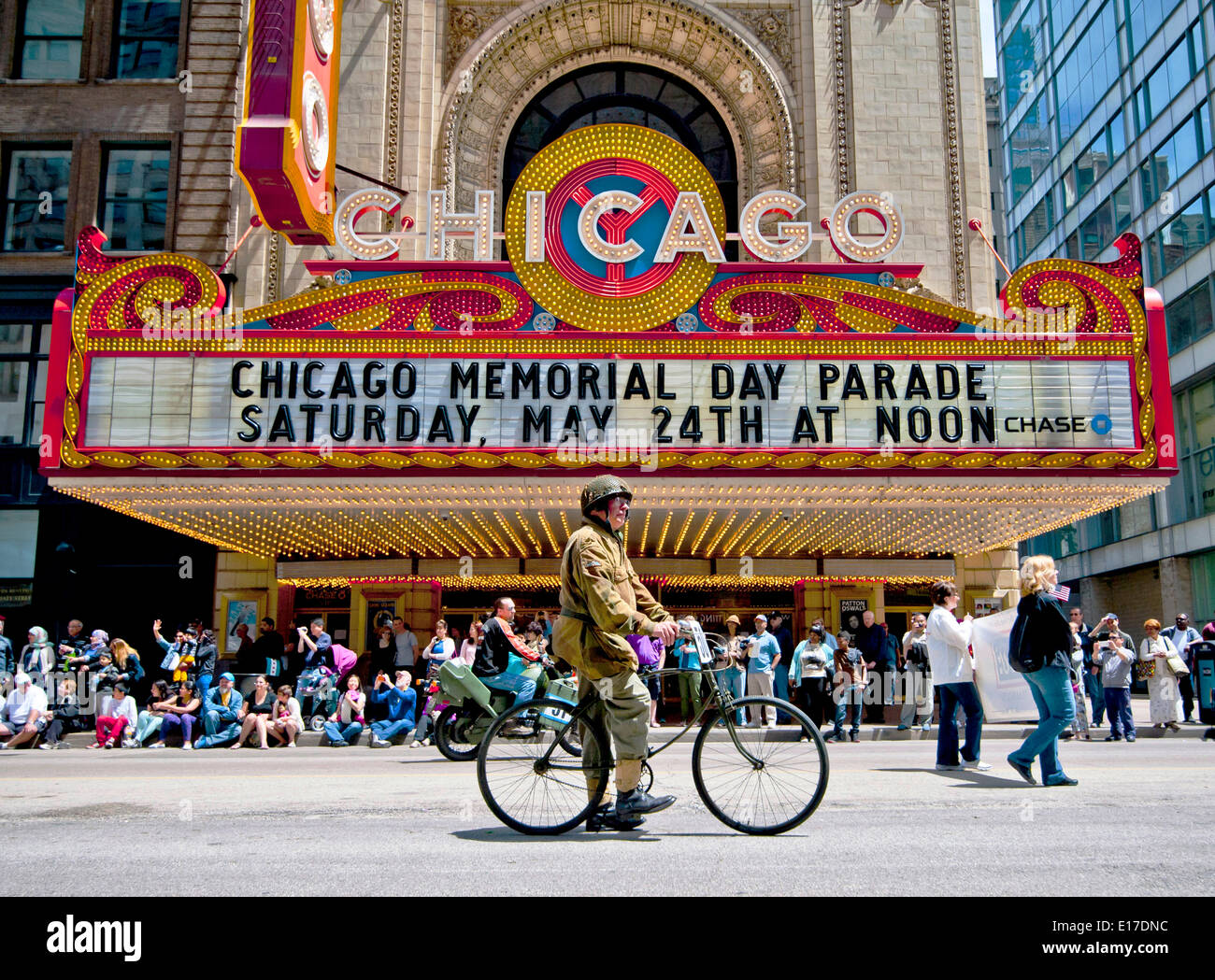 A veteran in WWII uniform rides a bicycle past the Chicago Theatre during a Memorial Day Parade down State Street  May 24, 2014 in Chicago, Illinois. Stock Photo