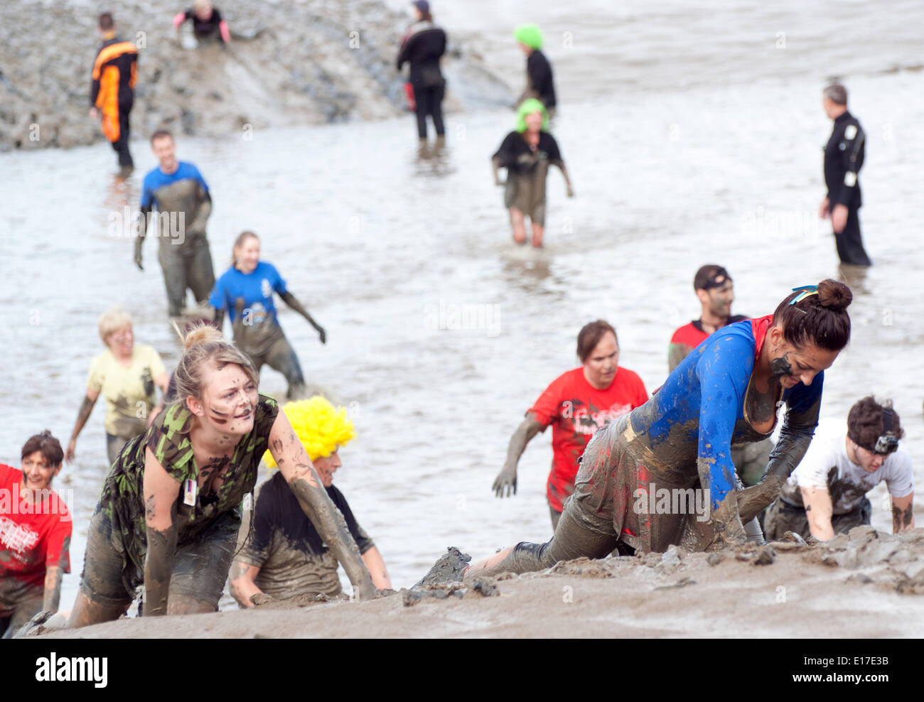 Maldon, UK. 25th May, 2014. GI Jane & Supergirl crawl to the finishing Maldon Mud Race 2014. Credit:  Tony Worpole/Alamy Live News Stock Photo