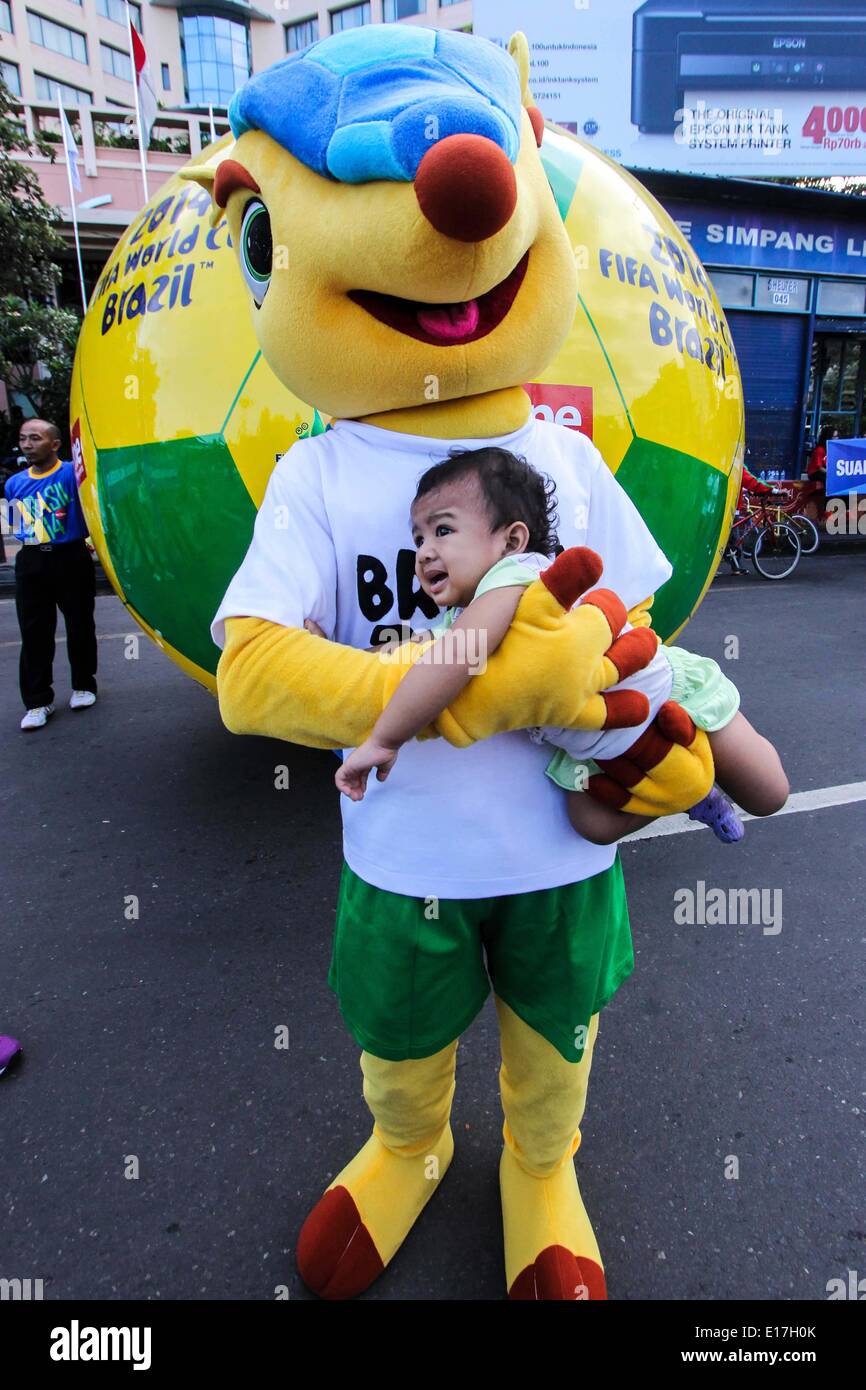 Semarang, Central Java, Indonesia. 25th May, 2014. SEMARANG, CENTRAL JAVA, INDONESIA - MAY 25: Armadillo, the 2014 World Cup mascot, holding a baby to welcome the 2014 FIFA World Cup, International men's football tournament scheduled to take place in Brazil from 12 June to 13 July 2014, in Semarang, Central Java, Indonesia on May 25, 2014. Credit:  Sijori Images/ZUMAPRESS.com/Alamy Live News Stock Photo