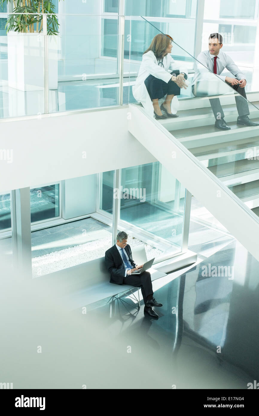 Doctor and administrator talking on hospital stairs Stock Photo