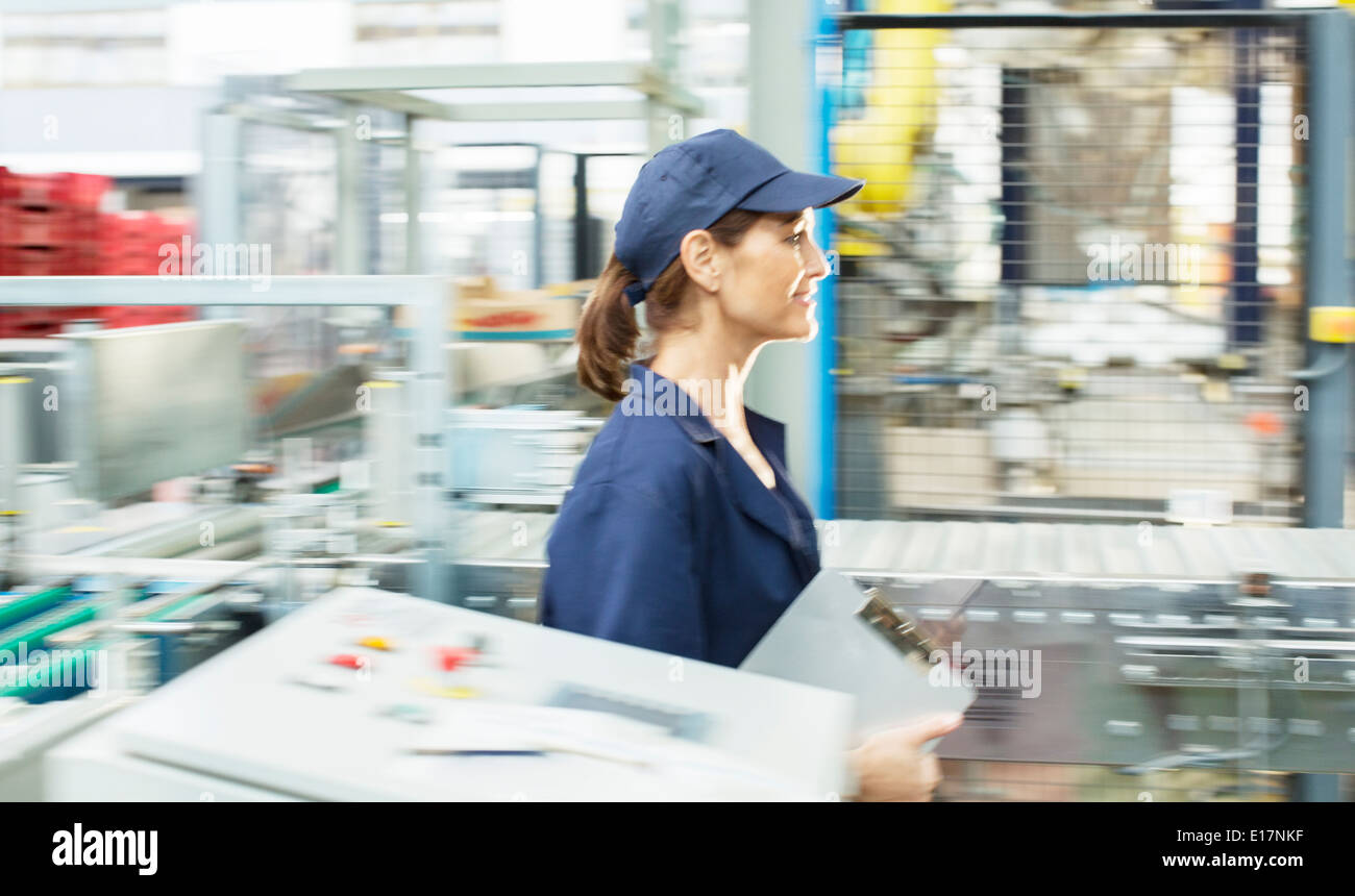 Worker with clipboard walking in food processing plant Stock Photo