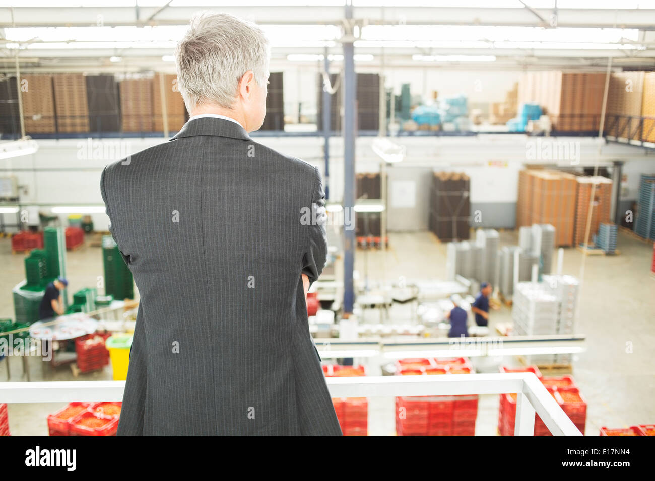 Supervisor watching workers in food processing plant Stock Photo