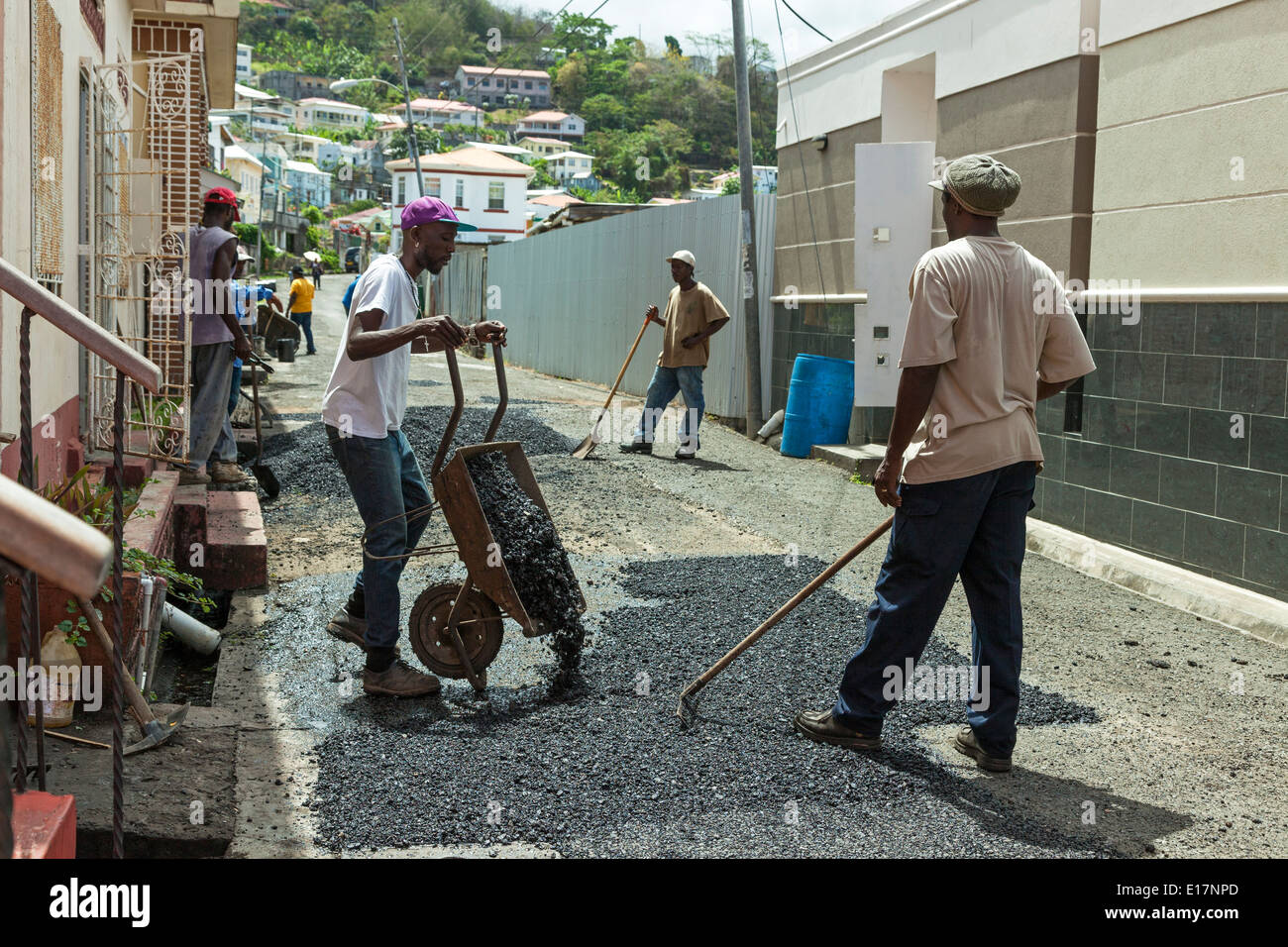 Workmen repairing a road, using tar and handheld tools, in St George, Grenada, East Indies Stock Photo