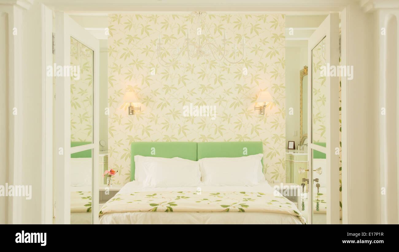 French doors open to luxury bedroom with wallpaper Stock Photo