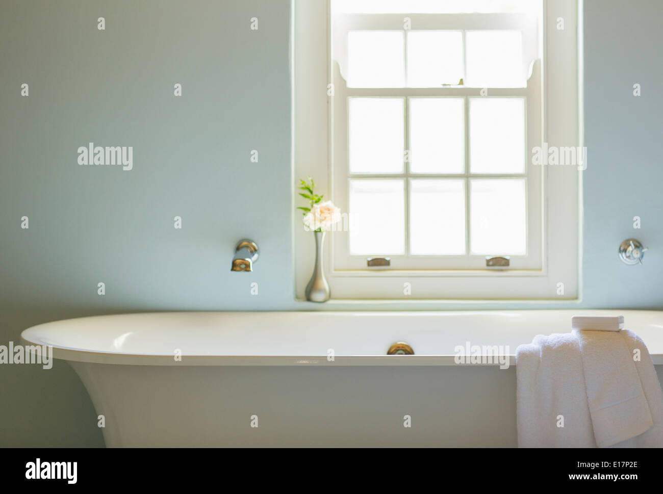 Soaking tub below window in luxury bathroom Stock Photo
