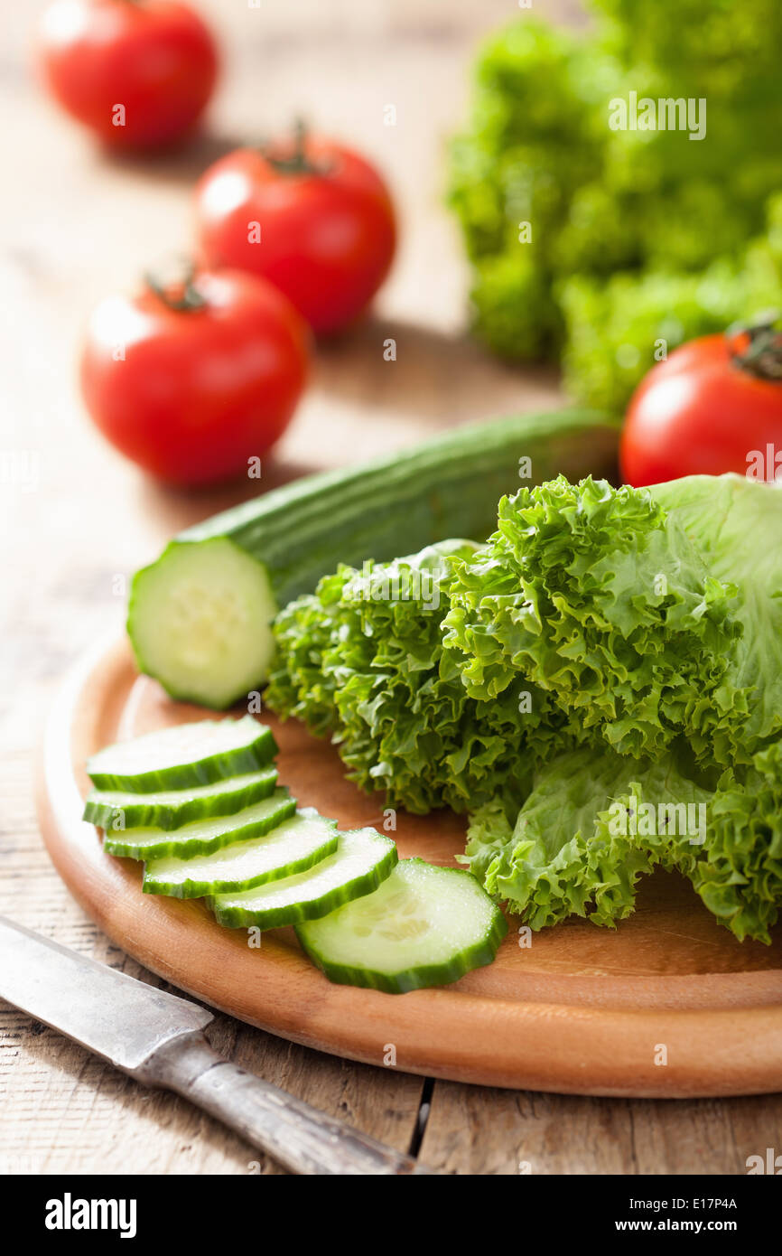 fresh cucumber tomatoes and salad leaves on chopping board Stock Photo ...