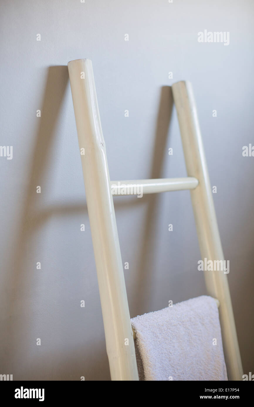 Towel hanging on ladder in bathroom Stock Photo