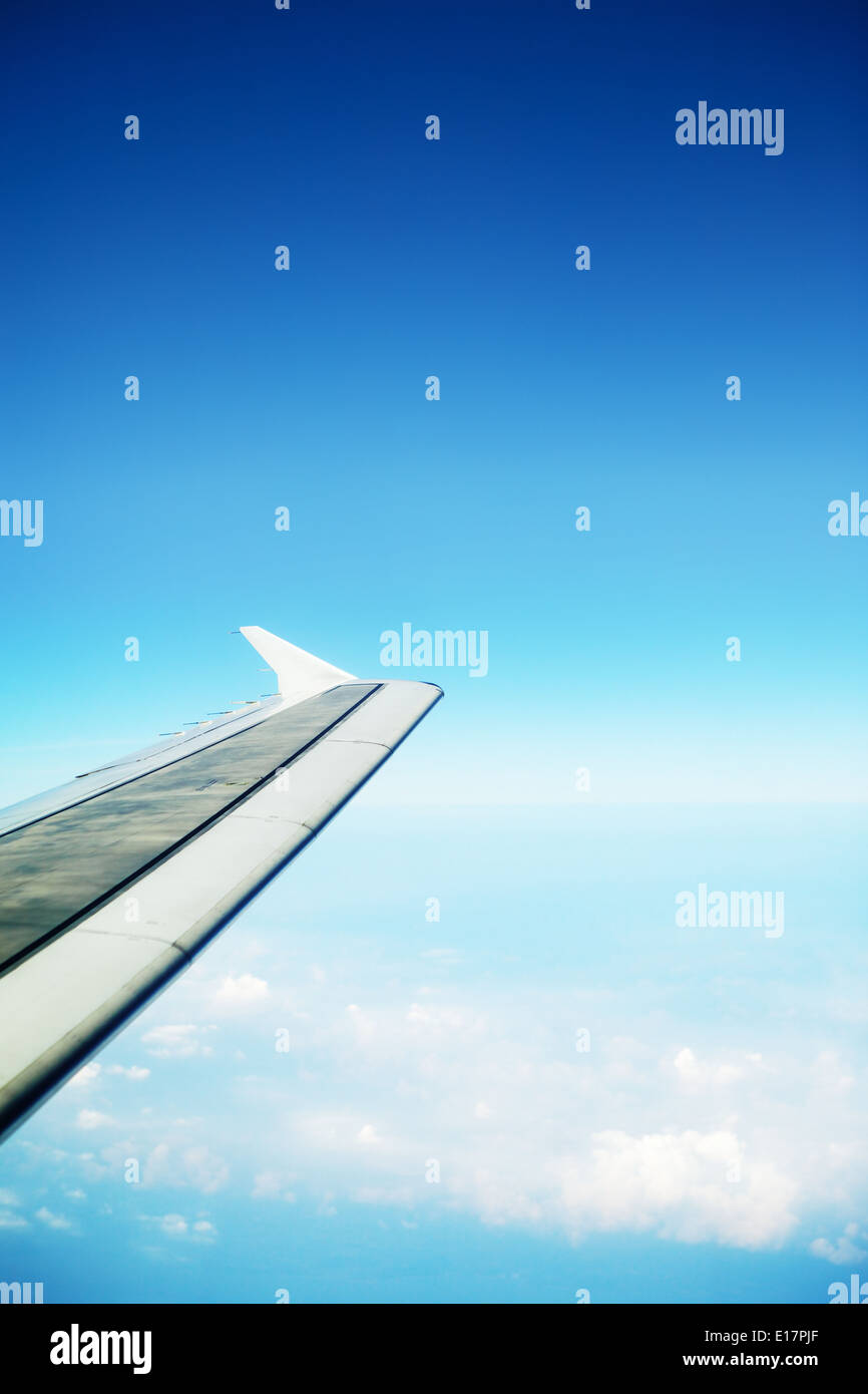 clouds in a blue sky and plane wing, view from airplane Stock Photo