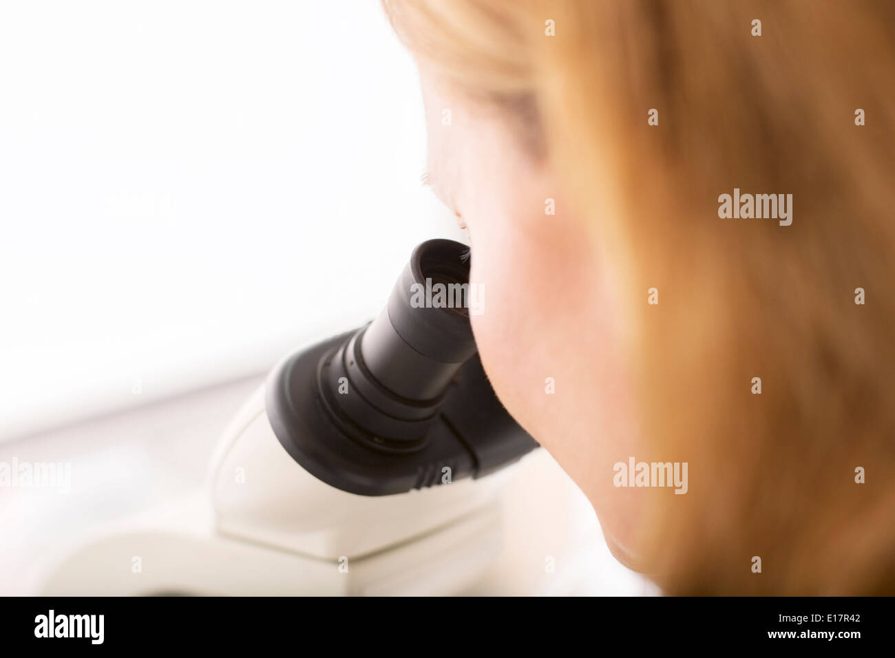 Close up of scientist using microscope in laboratory Stock Photo