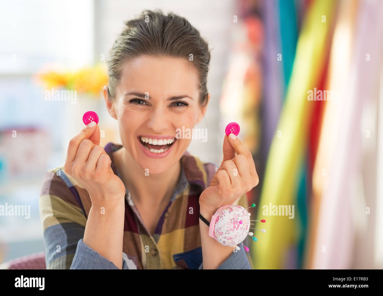 Happy seamstress showing buttons Stock Photo Alamy
