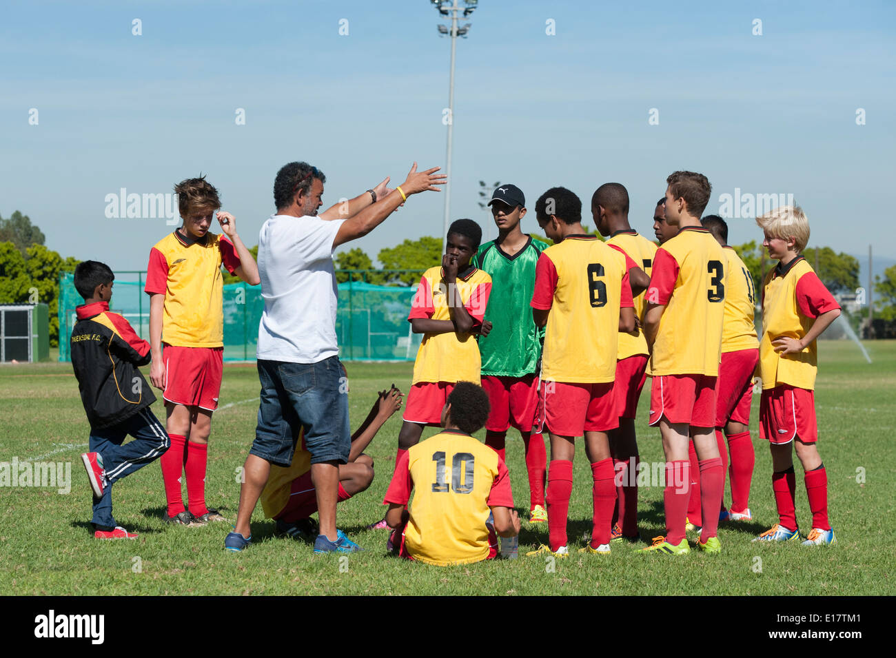 Coach instructing junior football team during the break, Cape Town, South Africa Stock Photo