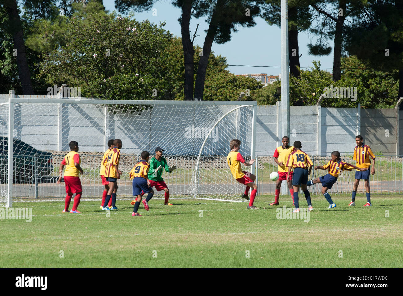 Goalkeeper trying to catch a shot on goal other football players watching, Cape Town, South Africa Stock Photo