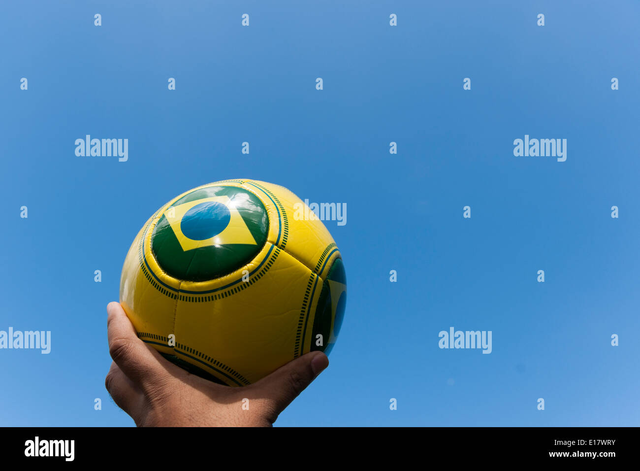 Man holding football in sky for Brazil World Cup 2014. Stock Photo