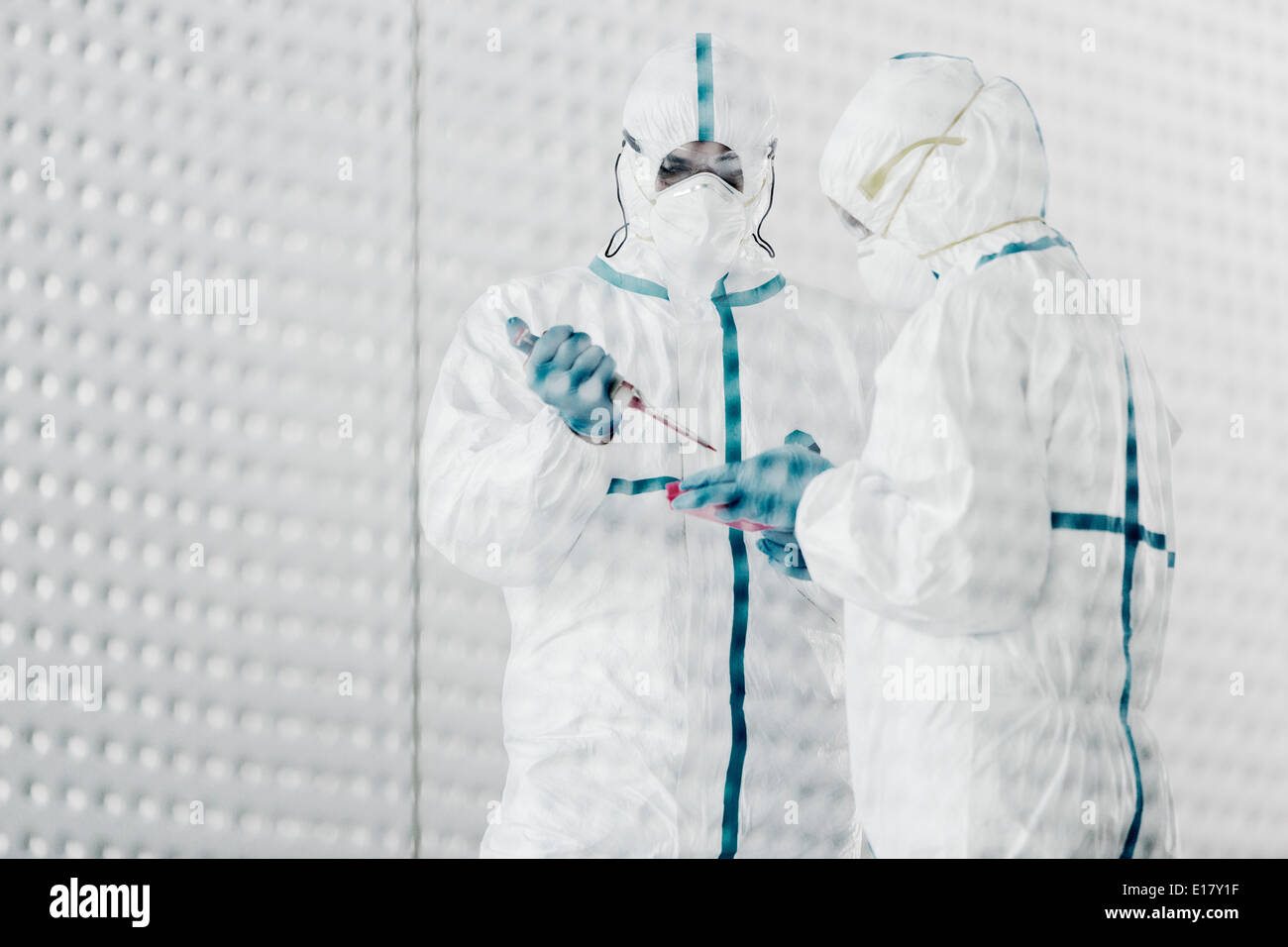 Scientists in clean suits working in laboratory Stock Photo