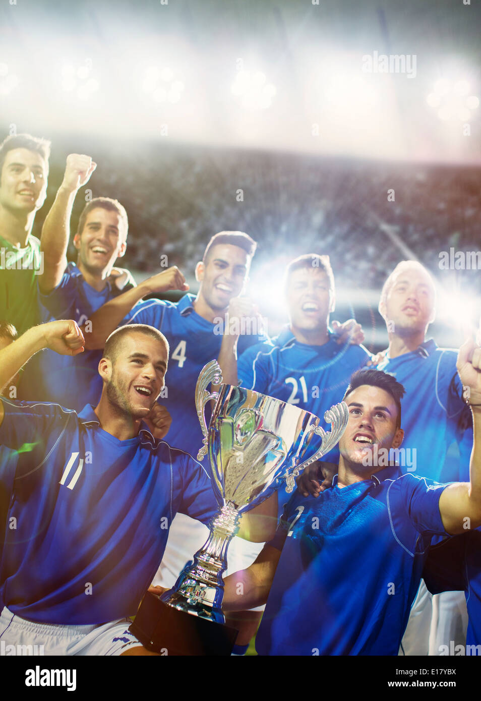 Soccer team celebrating with trophy in stadium Stock Photo
