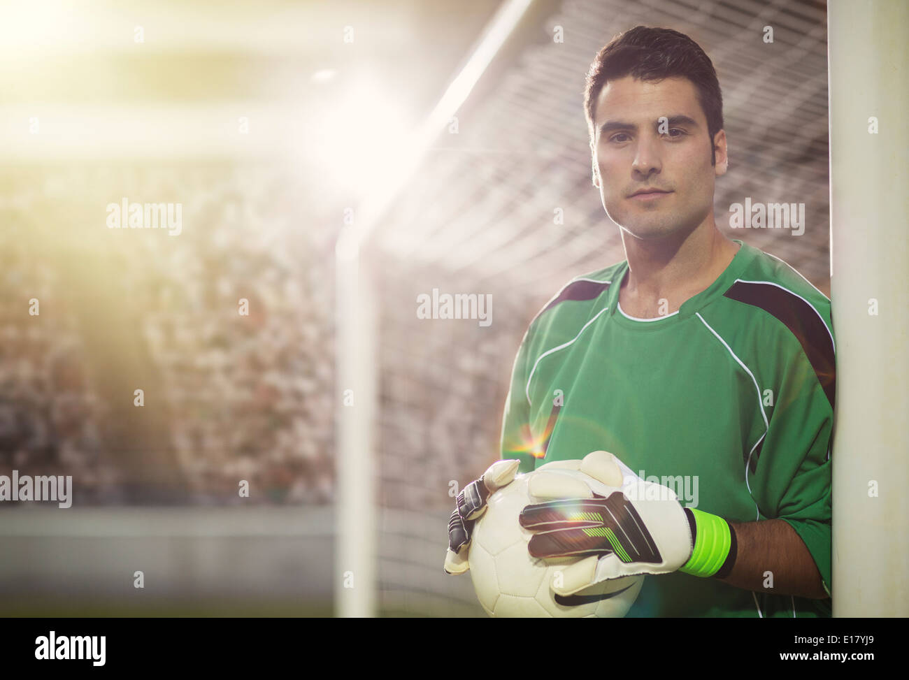 Goalie holding ball in soccer net Stock Photo Alamy